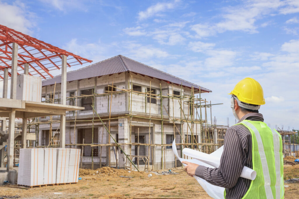 Contractor inspecting new home construction site framework