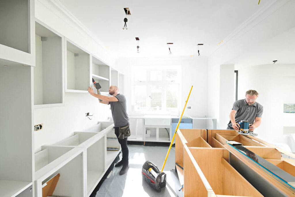 Kitchen additions contractor installing cabinets in a bright modern space