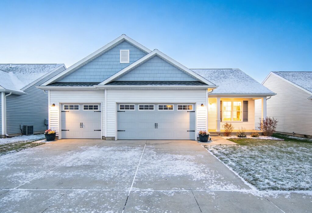 High-quality realistic illustration of a newly built attached garage in a suburban home in Appleton, Wisconsin, modern Midwestern architecture, double-car garage connected to a house, winter-friendly design with insulated walls and sloped roof, concrete driveway, neat lawn, soft natural daylight, residential neighborhood setting, clean and professional composition, architectural visualization style, ultra-detailed, 4K, wide angle, realistic textures, siding and brick exterior, clear blue sky, construction guide theme, informative
