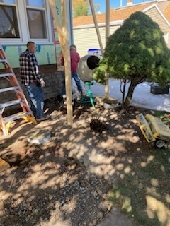 Contractors mixing concrete for porch foundation or structural repair