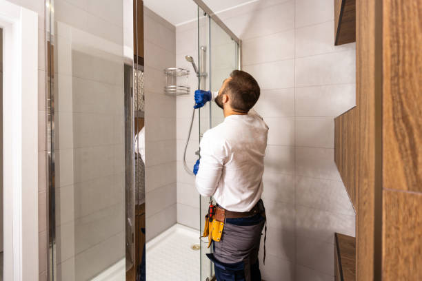 Technician installing shower fixtures in a renovated bathroom