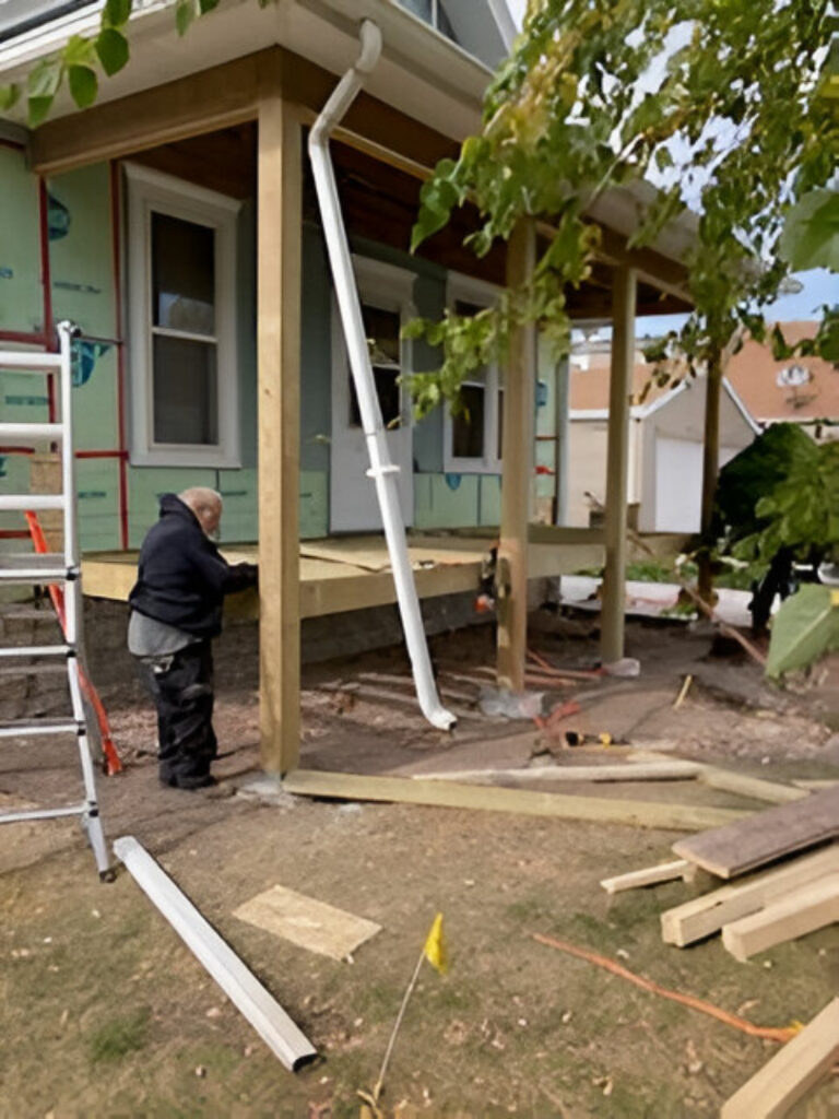 Builder working on deck foundation with framing and materials for home