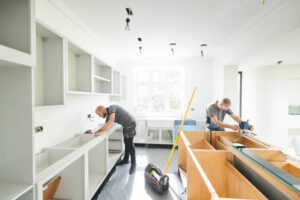 Skilled contractors setting up kitchen cabinetry during remodel