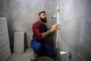 Bathroom construction worker installing tiles for a bathroom addition
