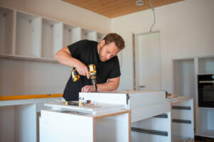 Contractors assembling custom cabinet drawers during kitchen renovation