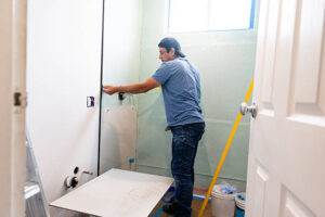 Worker measuring tiles for installation in bathroom renovation