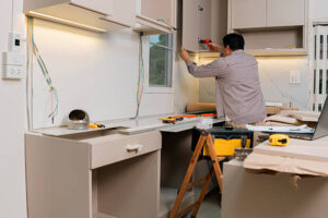 Contractor installing kitchen cabinets during renovation
