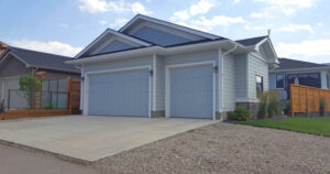 Completed attached garage with double doors and concrete driveway